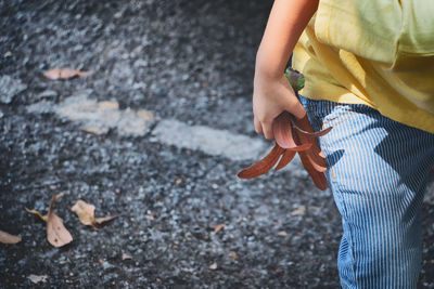 Midsection of boy holding plant outdoors