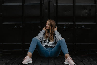 Full length of young woman sitting on seat