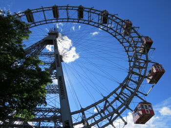 Low angle view of ferris wheel against blue sky