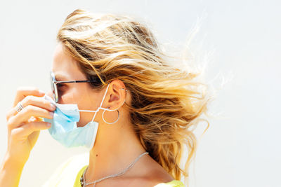 Woman putting on mask. on the street.