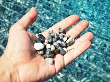 Close-up of hand holding pebbles