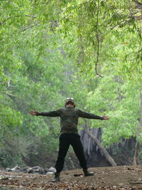 Full length of man standing by tree in forest