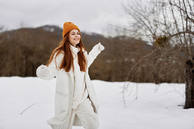 Portrait of young woman standing on snow