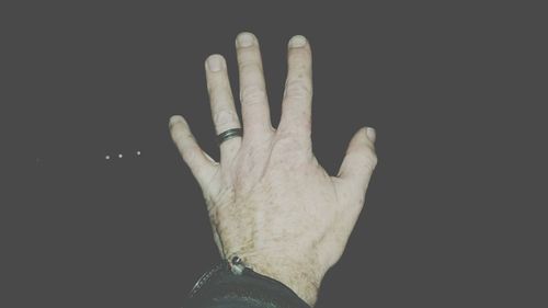Cropped image of hand over black background