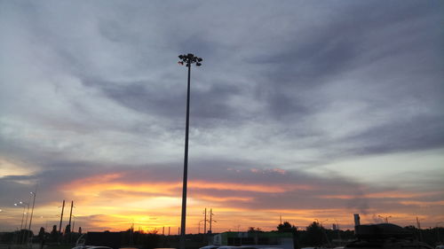 Silhouette street light against sky at sunset