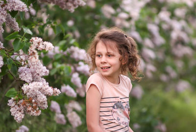 Portrait of smiling girl standing against plants