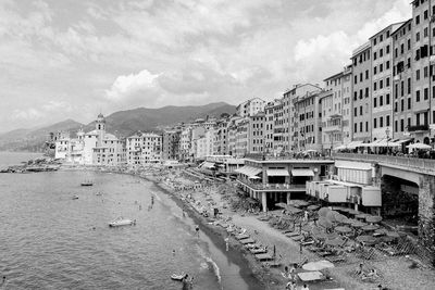 Buildings by sea against sky in city