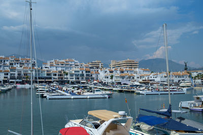 Sailboats moored at harbor against sky