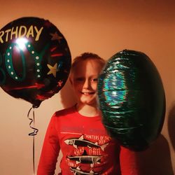 Portrait of smiling young woman holding balloons