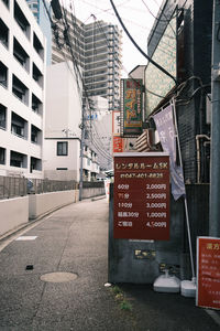 Road sign on street by buildings in city