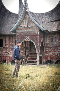 Full length of man standing in front of built structure