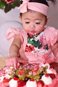 Cute girl eating cake at home