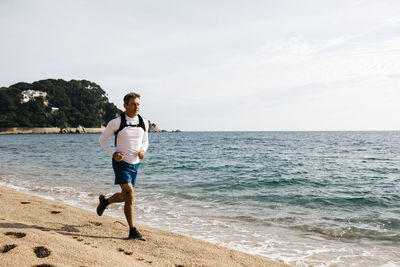 Full length of man on beach against sky