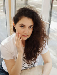 Portrait of smiling young woman sitting at home