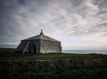 Old building on field against sky