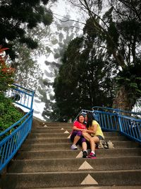 Full length of woman sitting on stairs