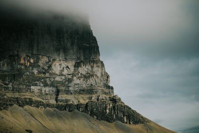 Low angle view of cliff against sky