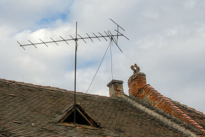 Romanian ceramic shingle roof with brick chimney and old television antenna