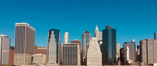 Skyscrapers in city against blue sky