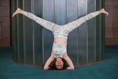 Full length of woman doing headstand