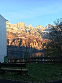 Built structure on field by mountains against sky