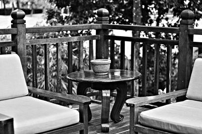 Empty chairs and table against railing