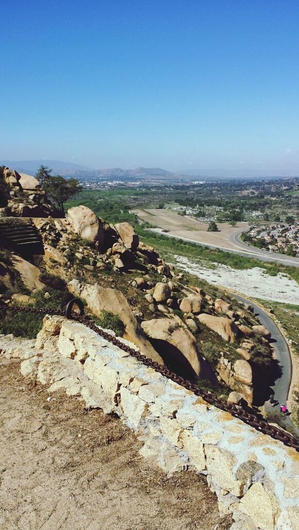 clear sky, copy space, blue, landscape, tranquility, mountain, rock - object, tranquil scene, nature, scenics, rock formation, beauty in nature, sunlight, day, non-urban scene, rock, outdoors, high angle view, hill, geology