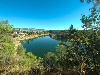 Scenic view of lake against clear blue sky