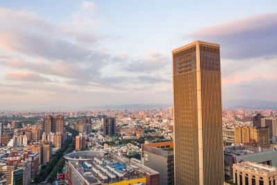 Modern buildings in city against cloudy sky