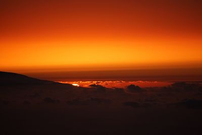 Scenic view of dramatic sky over silhouette landscape