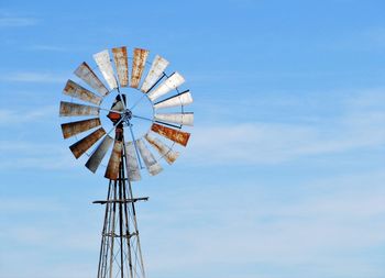 Low angle view of traditional windmill against blue sky