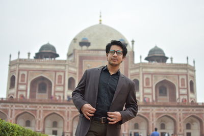 Portrait of man standing against building and sky