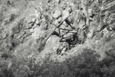 Man kitesurfing against rock formation