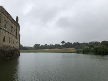 Scenic view of lake by building against sky