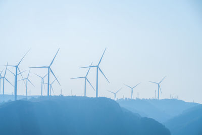 Wind turbines silhouetted on a hilltop