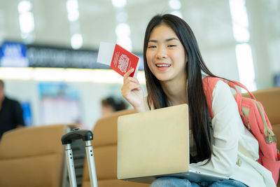 Portrait of young woman holding box