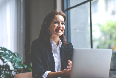 Smiling young woman using mobile phone