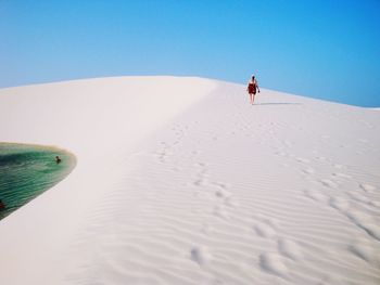 Man on sand against clear sky