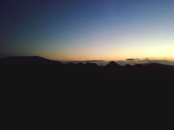 Scenic view of silhouette mountains against sky at sunset