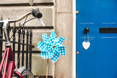 Close-up of bicycle hanging on wall against building