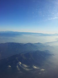 Scenic view of mountains against blue sky