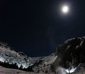 Scenic view of snowcapped mountains against sky at night