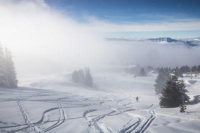 Ski slope under the mist with silhouettes