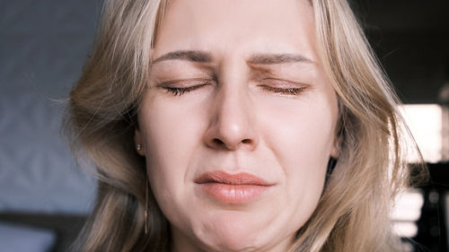 Portrait of crying grieving woman of 30 years. grimace of sadness with tears in her eyes 