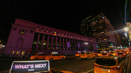 Traffic on illuminated city against sky at night