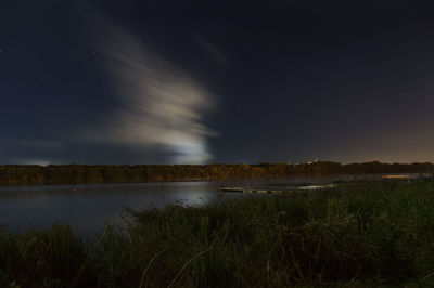 Scenic view of lake against clear sky at night