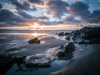 Scenic view of beach against dramatic sky