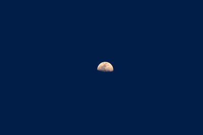 Low angle view of moon against clear blue sky