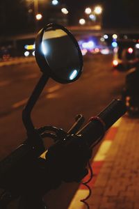 Close-up of illuminated lighting equipment on street at night