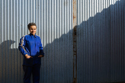 Portrait of man standing on metal grate